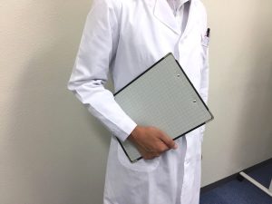 カルテを持つ白衣の男性